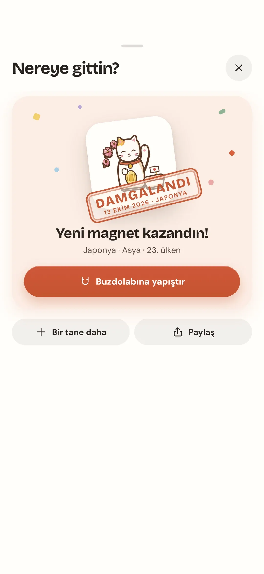 Damga ekranı: "Japonya" damgalı şans kedisi magneti ve "Yeni magnet kazandın!" yazısı