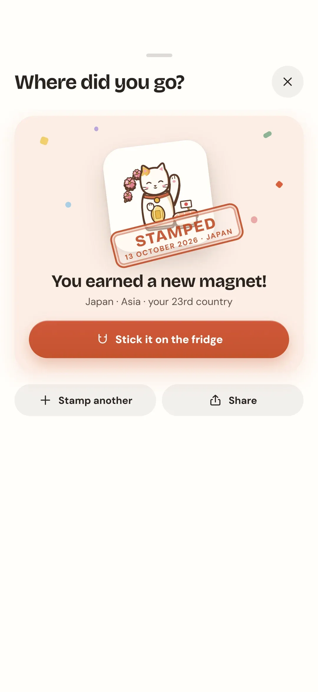 The stamp screen: a lucky-cat magnet stamped "Japan", with the line "You earned a new magnet!"